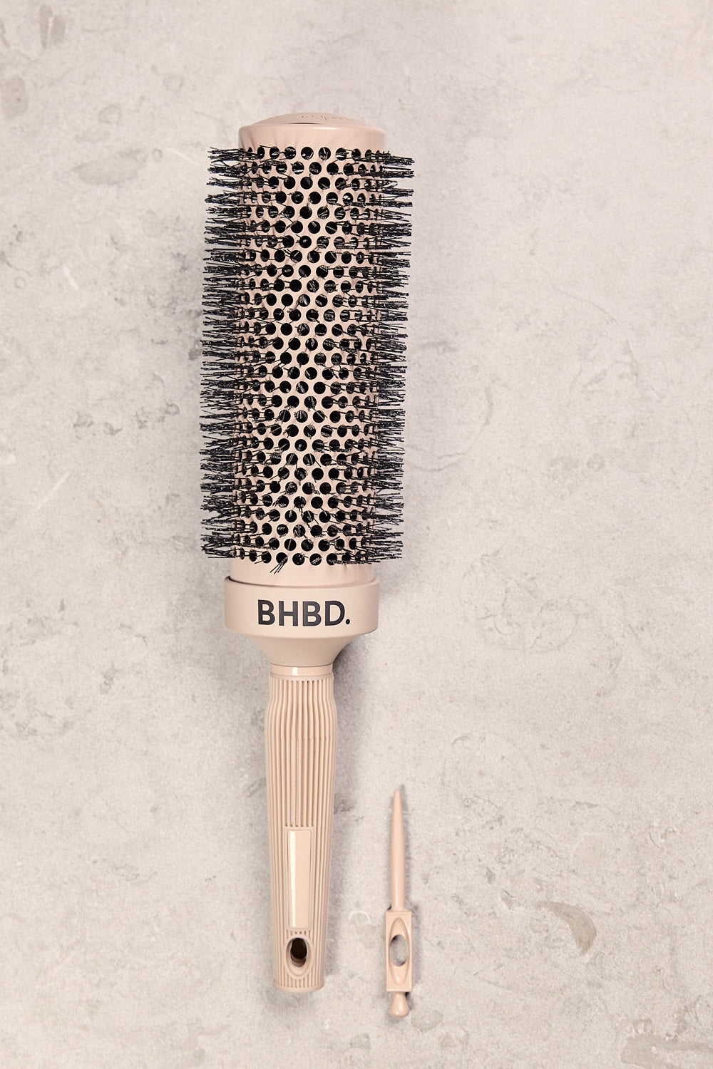 BHBD round brush med ergonomiskt handtag och löstagbart sektionsverktyg, utformad för exakt styling och effektiv föning, placerad på en neutral bakgrund.