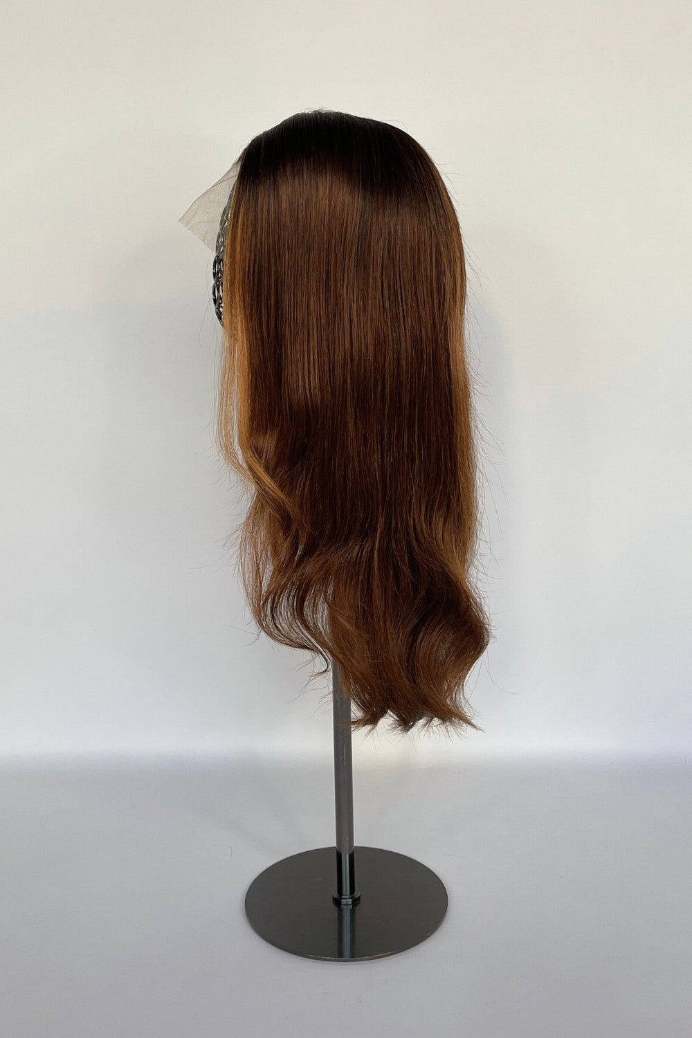 Premium BHBD half & full lace wig in a warm brown shade with soft, flowing waves, displayed on a mannequin stand. Made with 100% real Remy hair, offering a natural parting and seamless, elegant look.