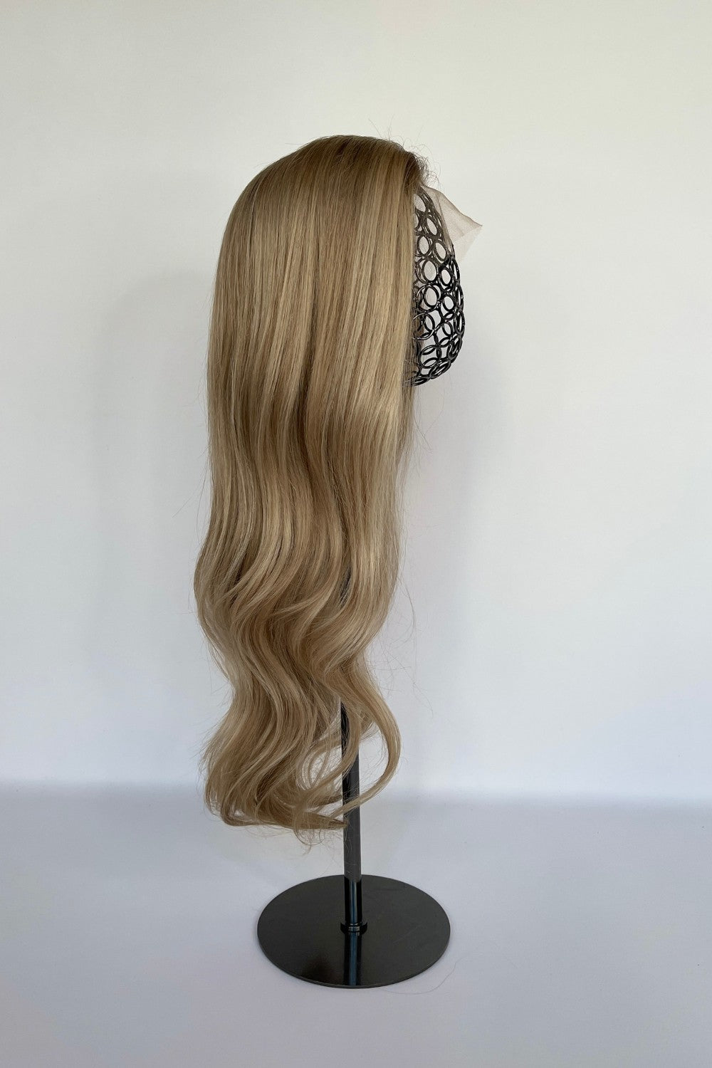 Premium BHBD half or full lace wig in a sandy blonde shade with long, soft waves cascading down. Displayed on a mannequin stand, made with 100% real Remy hair for a natural parting and seamless, elegant finish.