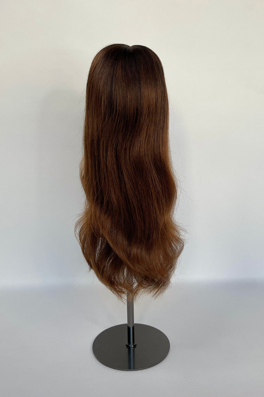 Premium BHBD half & full lace wig in a warm brown shade with soft, flowing waves, displayed on a mannequin stand. Made with 100% real Remy hair, offering a natural parting and seamless, elegant look.