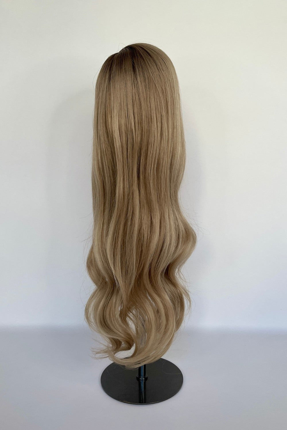 Premium BHBD half or full lace wig in a sandy blonde shade with long, soft waves cascading down. Displayed on a mannequin stand, made with 100% real Remy hair for a natural parting and seamless, elegant finish.