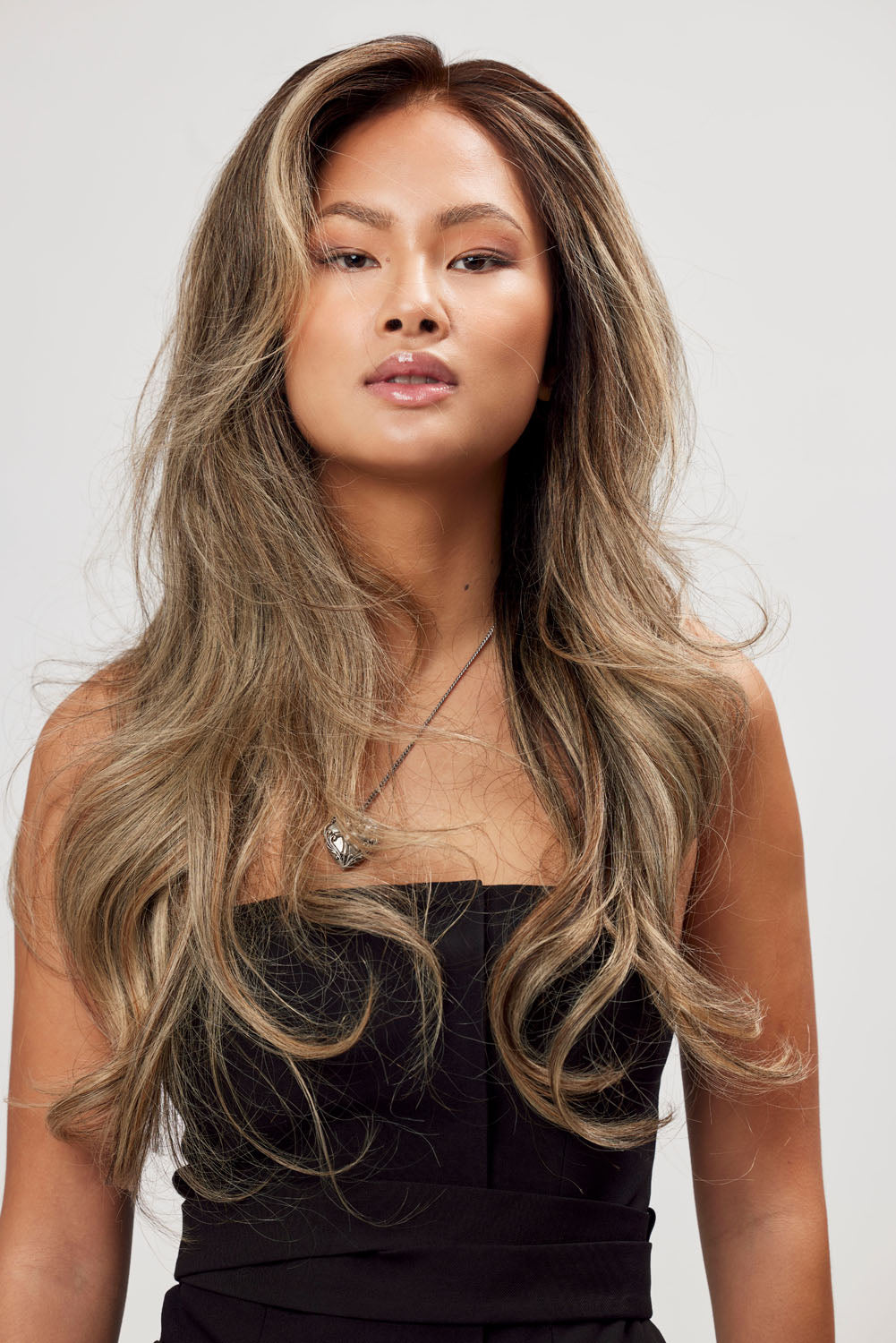 Modell visar BHBD Mafiosa Muse peruk: 50 cm. Peruken har en mörkbrun bas, snygg balayage, handknutet hår och naturlig hårlinje.