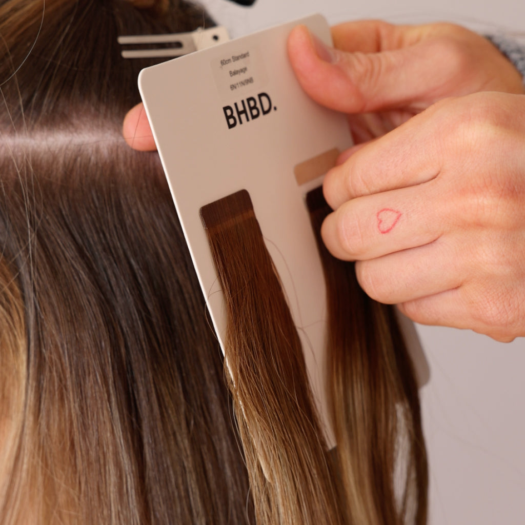 A woman selecting the color of her BHBD hair extensions.